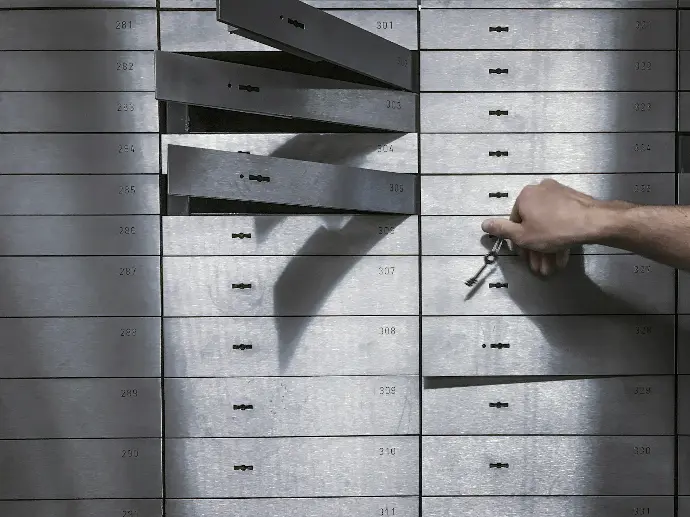 a hand is holding a bunch of keys in front of a metal locker